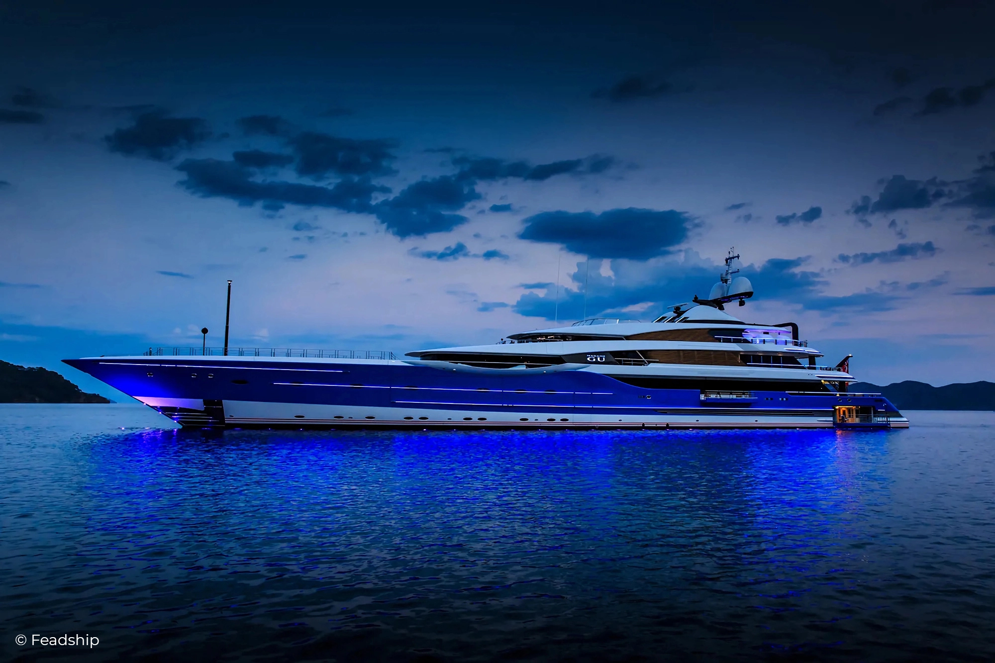 Motor Yacht Madam Gu from Feadship. Twilight and with a deep blue painted hull. Illuminated Yacht Sign from Lumenautica.